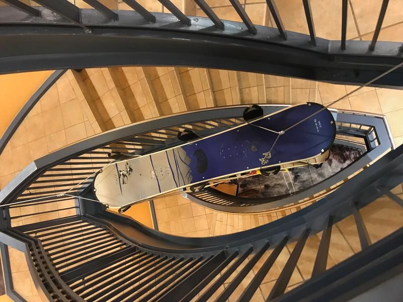 Stair case with a wake board suspended in the middle.