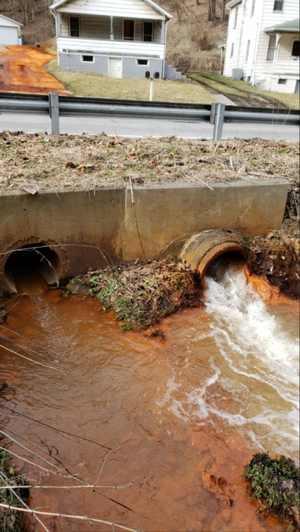 Orange colored water flowing from two drainage tubes