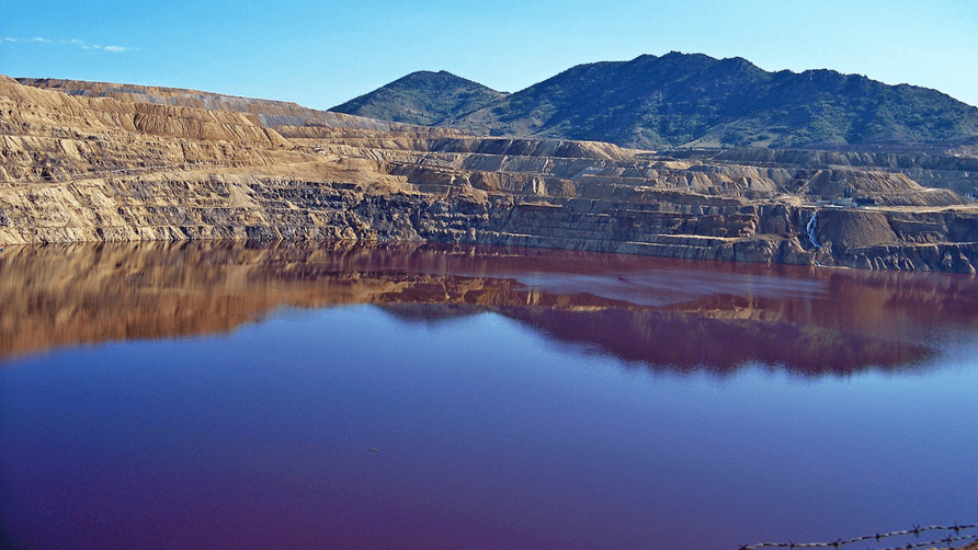 An extensive copper mining operation created the Berkeley Pit, which is part of a massive Superfund site located in Butte. Credit: James St. John / Wikimedia Commons