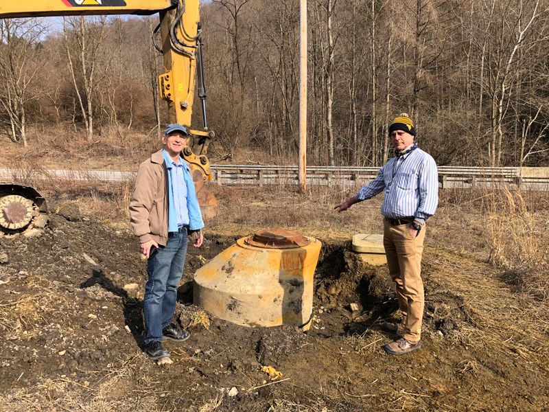 WVU researchers Jeff Skousen and Paul Ziemkiewicz visit the site where an uncontrolled discharge of acidic water flowed through a broken manhole near an acid mine drainage treatment site in Albright, Preston County. 